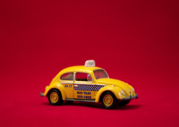 Yellow toy taxi car with red background