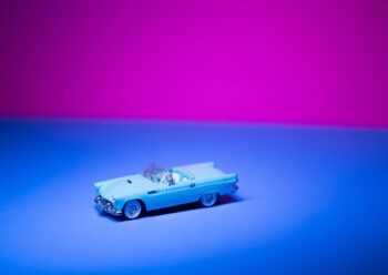Vintage toy car with blue and pink background