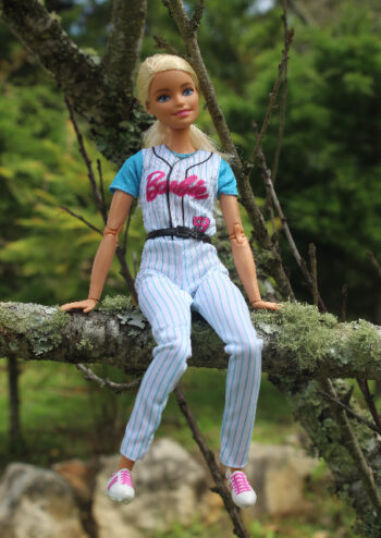 Female doll sitting on a branch