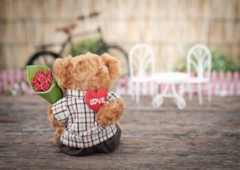 Teddy bear holding flowers and a love heart
