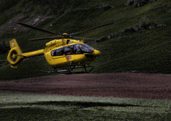 Yellow helicopter that has landed on mountain side