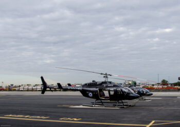 Two black helicopters on helipad