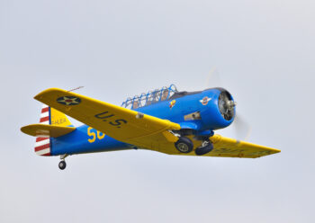 Old US blue and yellow propeller plane in flight