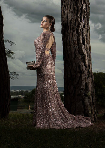 Female wearing evening dress standing next to tree
