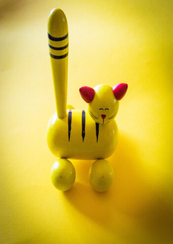 Yellow toy cat pull along with yellow background