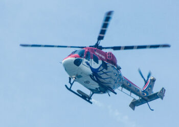 Red and white helicopter in flight