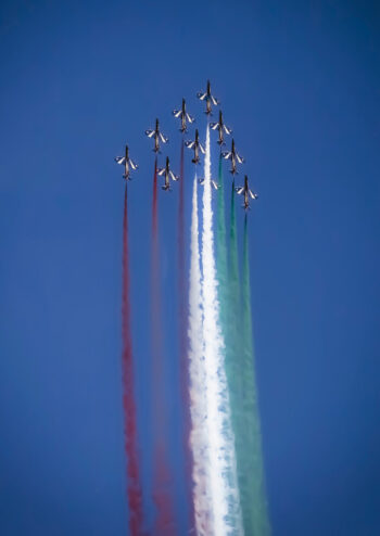 Italian air force flying in arrow formation with coloured smoke