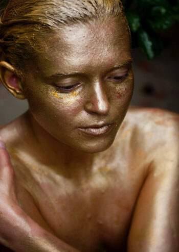 Female covered in gold glitter