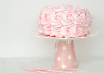 Pink iced cake on a stand