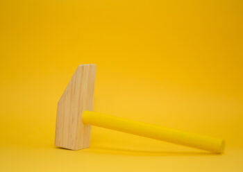 Wooden toy hammer with yellow background