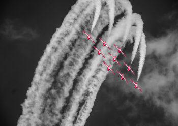 Red Arrows flying in formation with white smoke