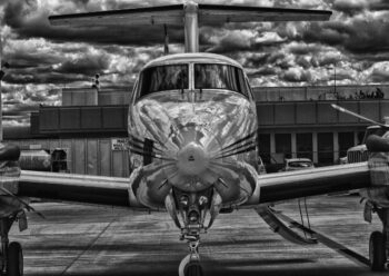 Front of plane at airport black and white