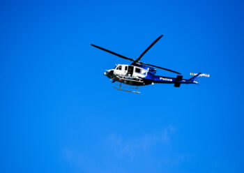 Blue and white police helicopter in flight