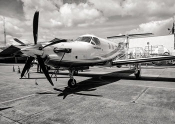 Small propeller plane on airfield black and white